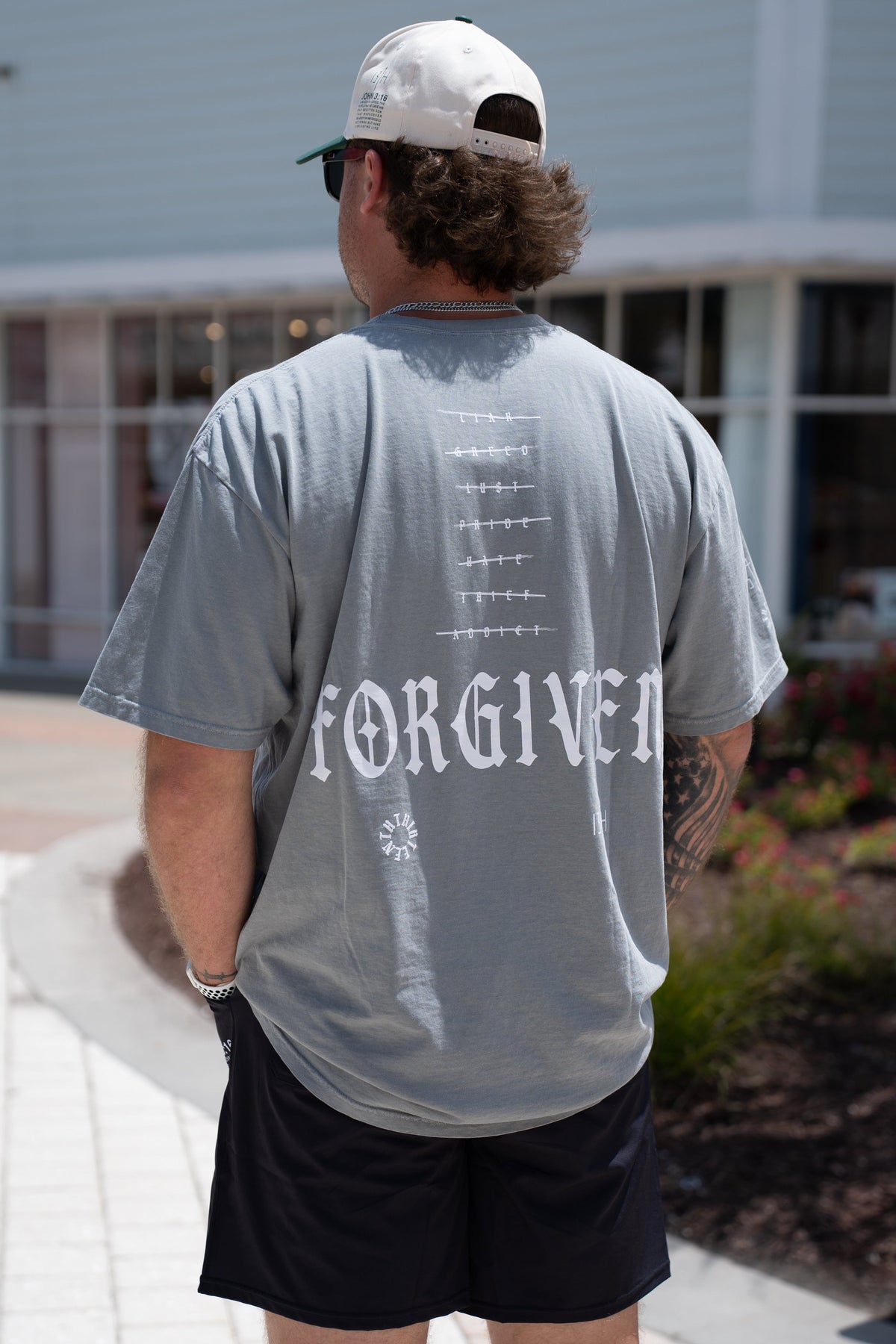 Gray premium tee with back FORGIVEN lettering graphic and small emblem, crew neck short sleeves