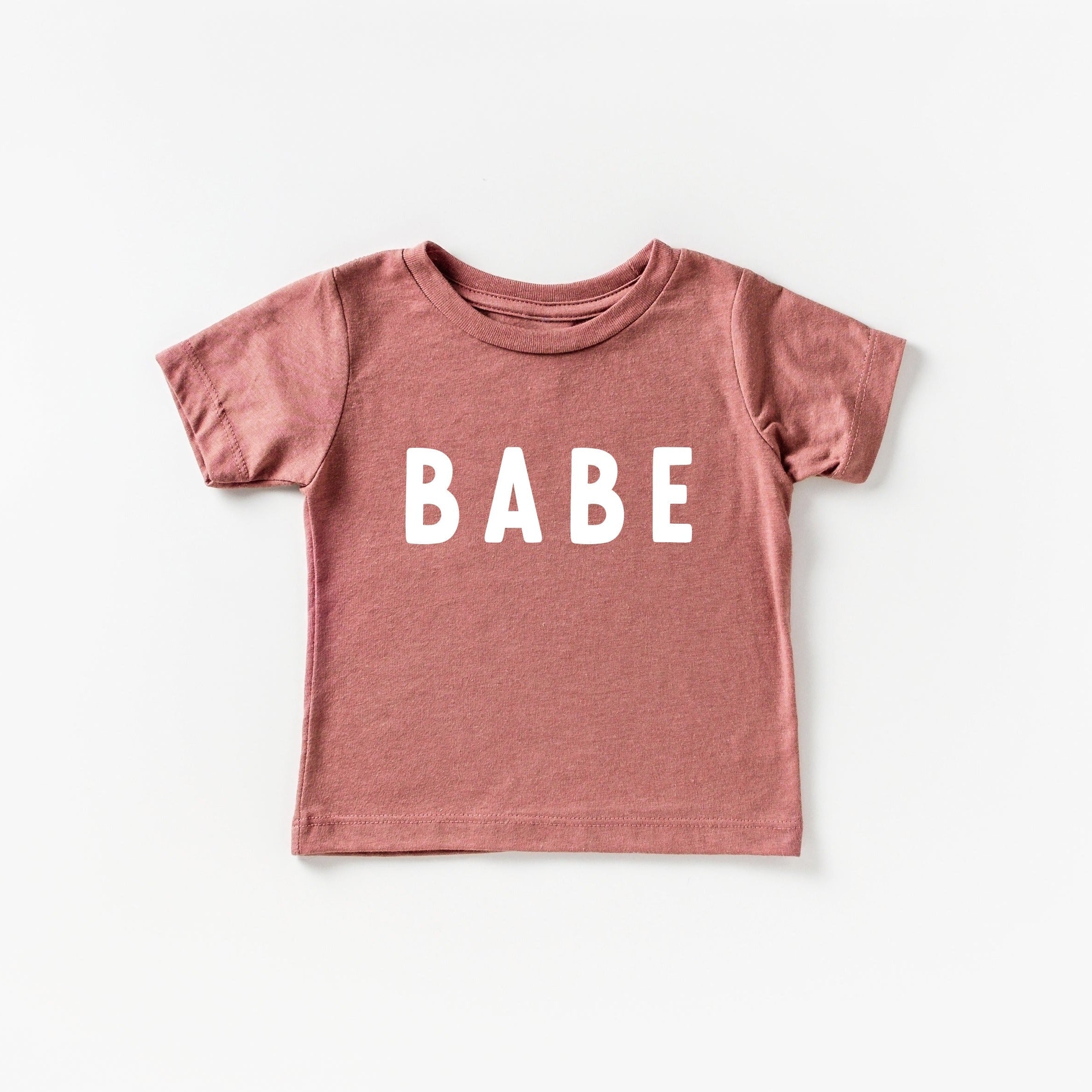 Dusty rose baby T-shirt with white "BABE" rounded-letter print