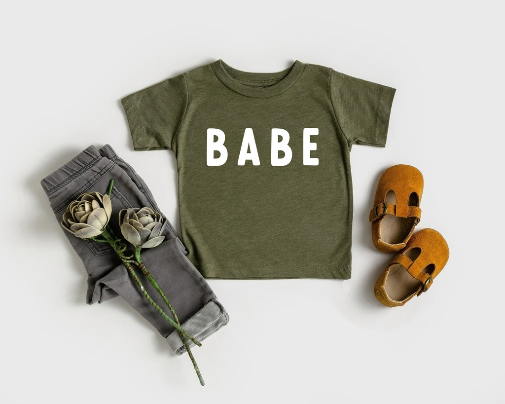 Olive green baby T-shirt with white "BABE" rounded-letter print