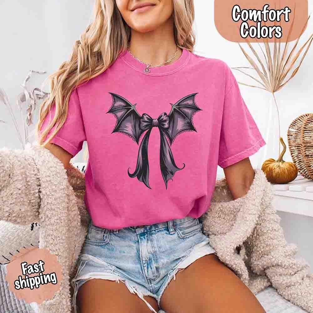 Magenta pink Halloween T-shirt with black and purple bat bow graphic on front