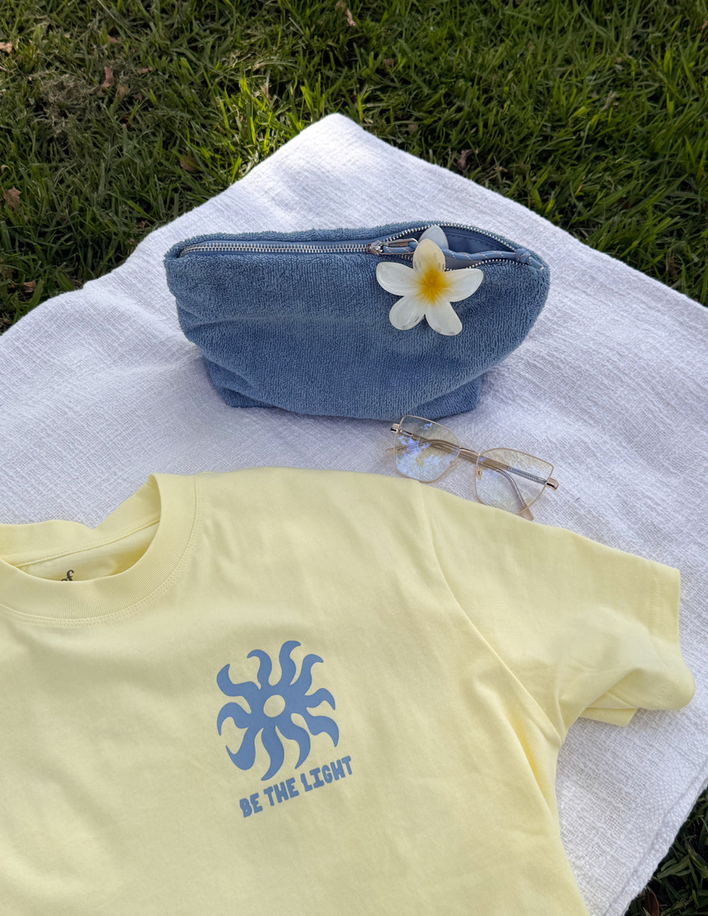 Yellow unisex T-shirt with blue sunburst logo and BE THE LIGHT lettering