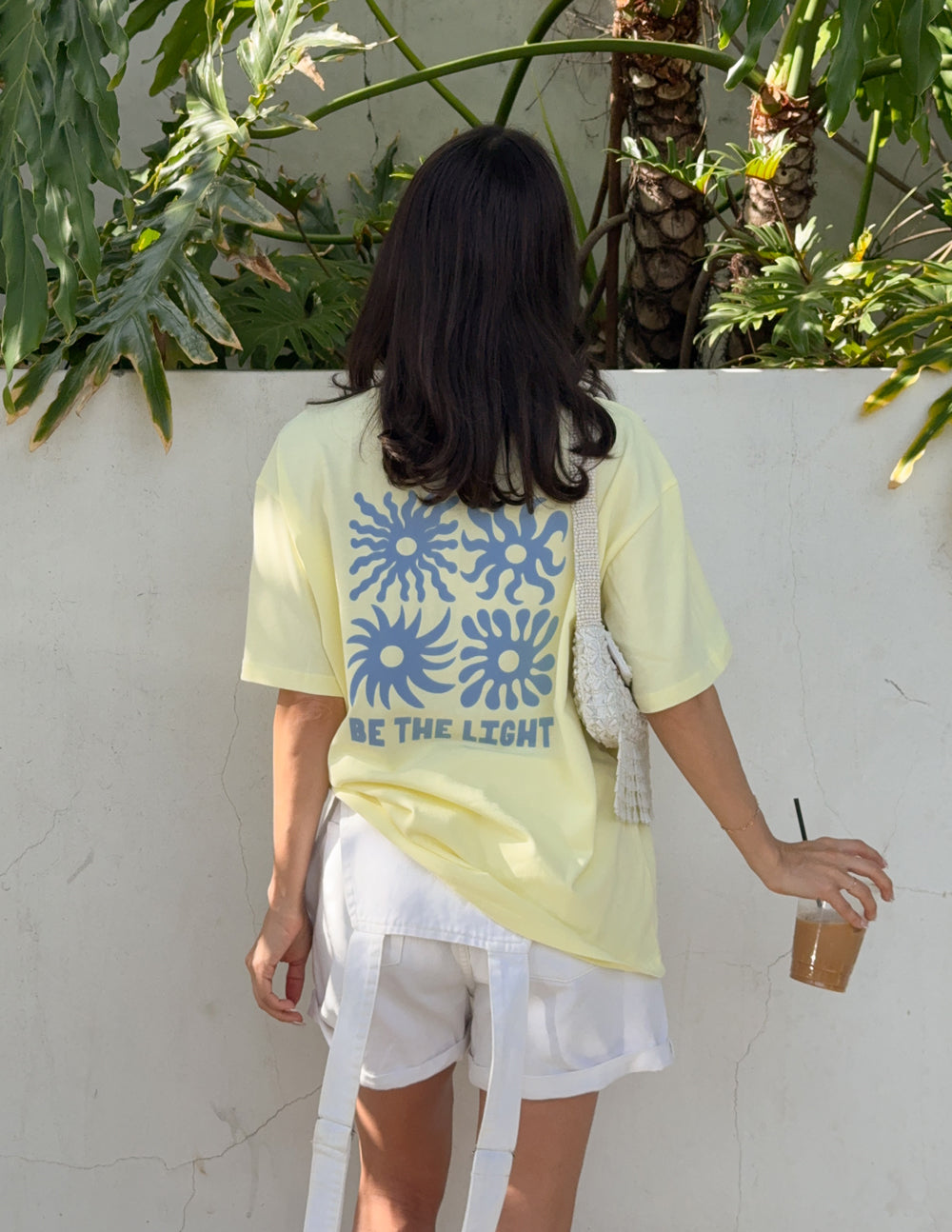 Yellow unisex T-shirt back view with blue sunburst graphic and BE THE LIGHT text