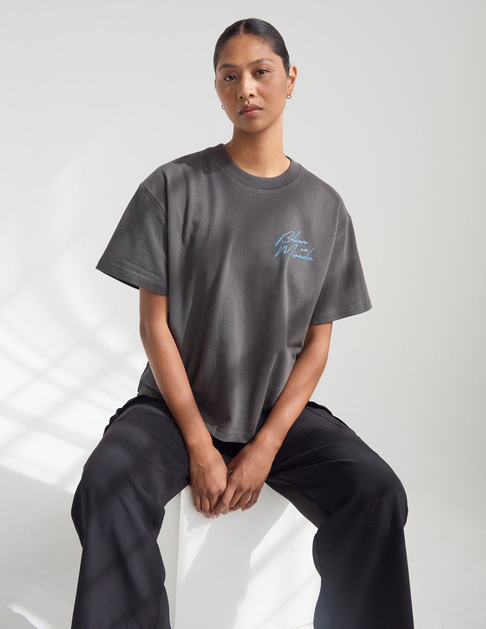 Dark gray crew-neck T-shirt with small cursive front logo