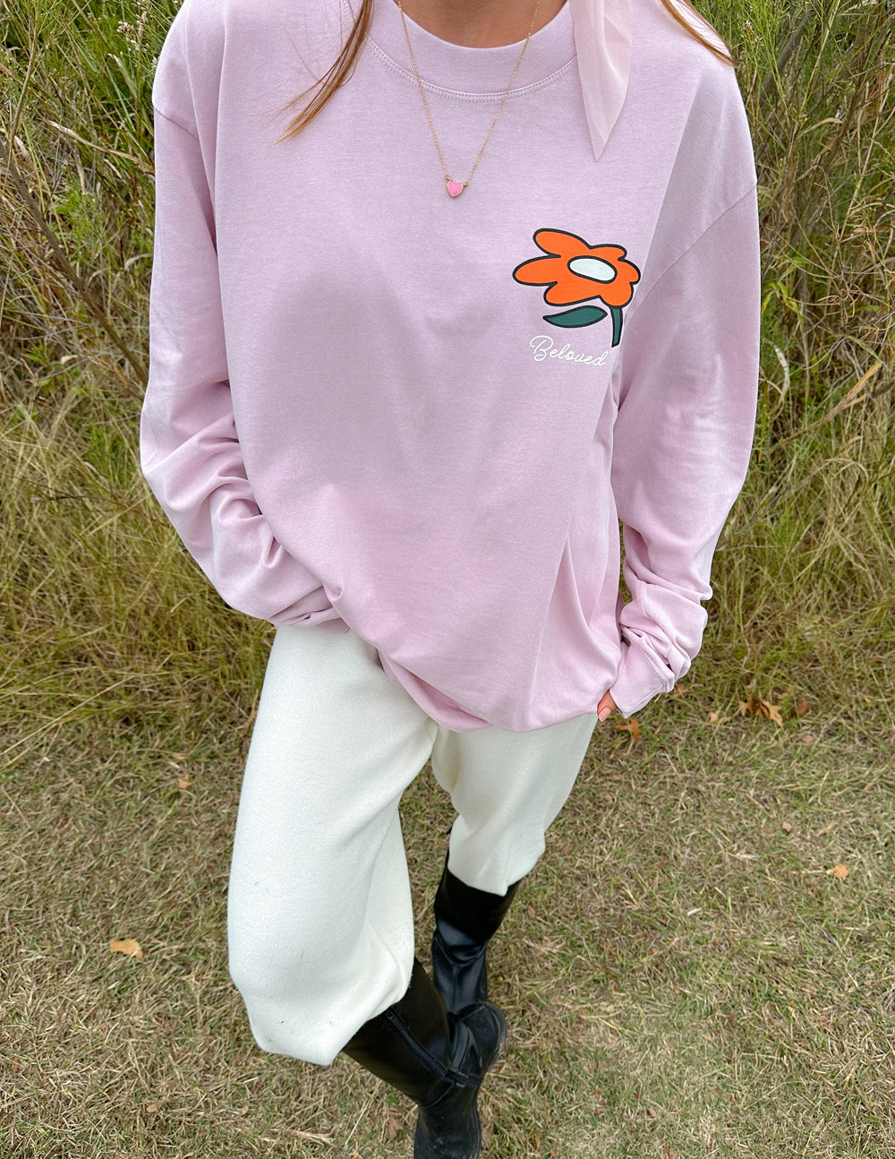 Light purple long-sleeve unisex tee with small orange flower logo at front