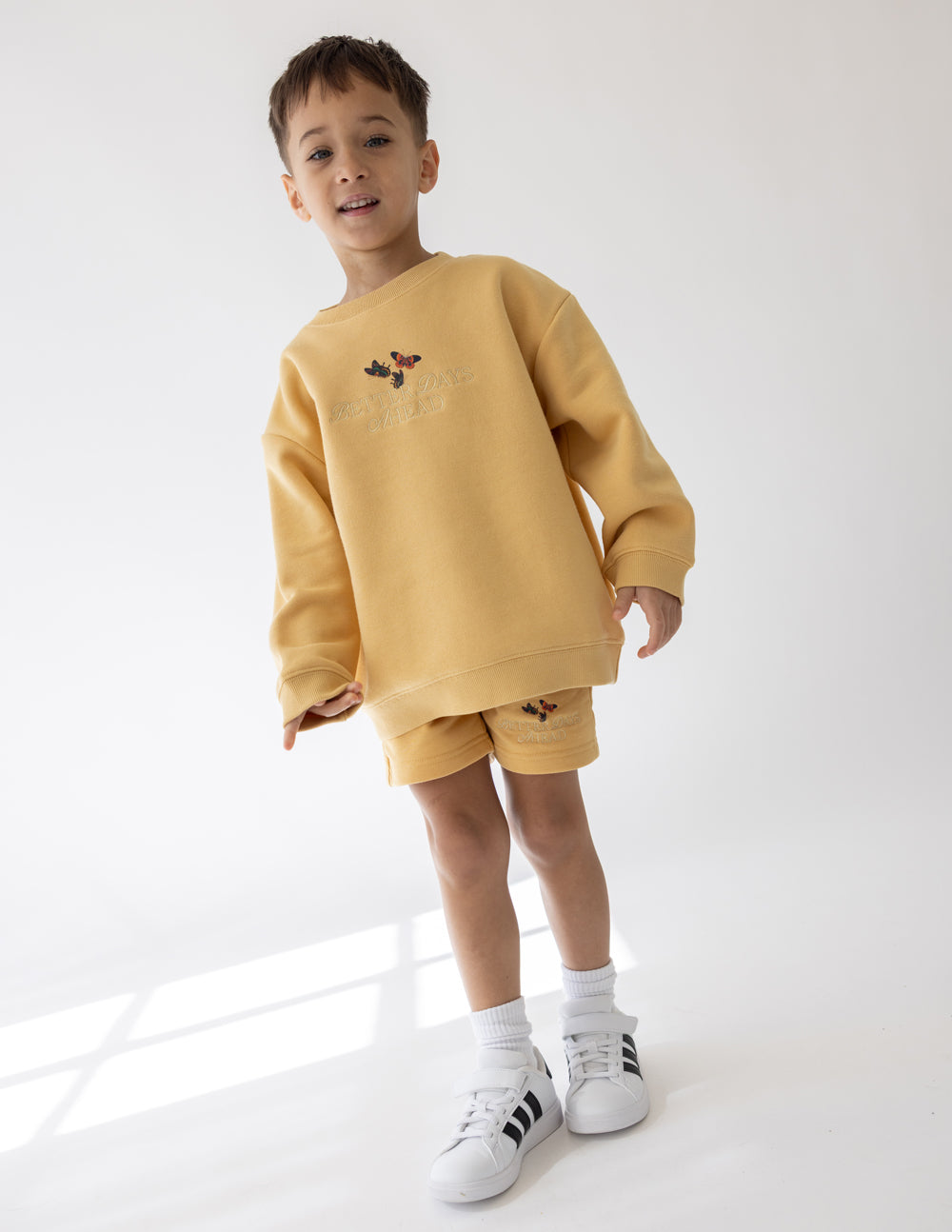 Kids yellow crewneck sweatshirt with butterfly chest graphic and long sleeves