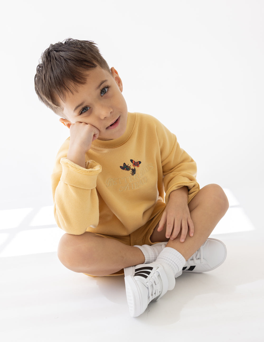Kids yellow crewneck sweatshirt with small butterfly graphic on chest