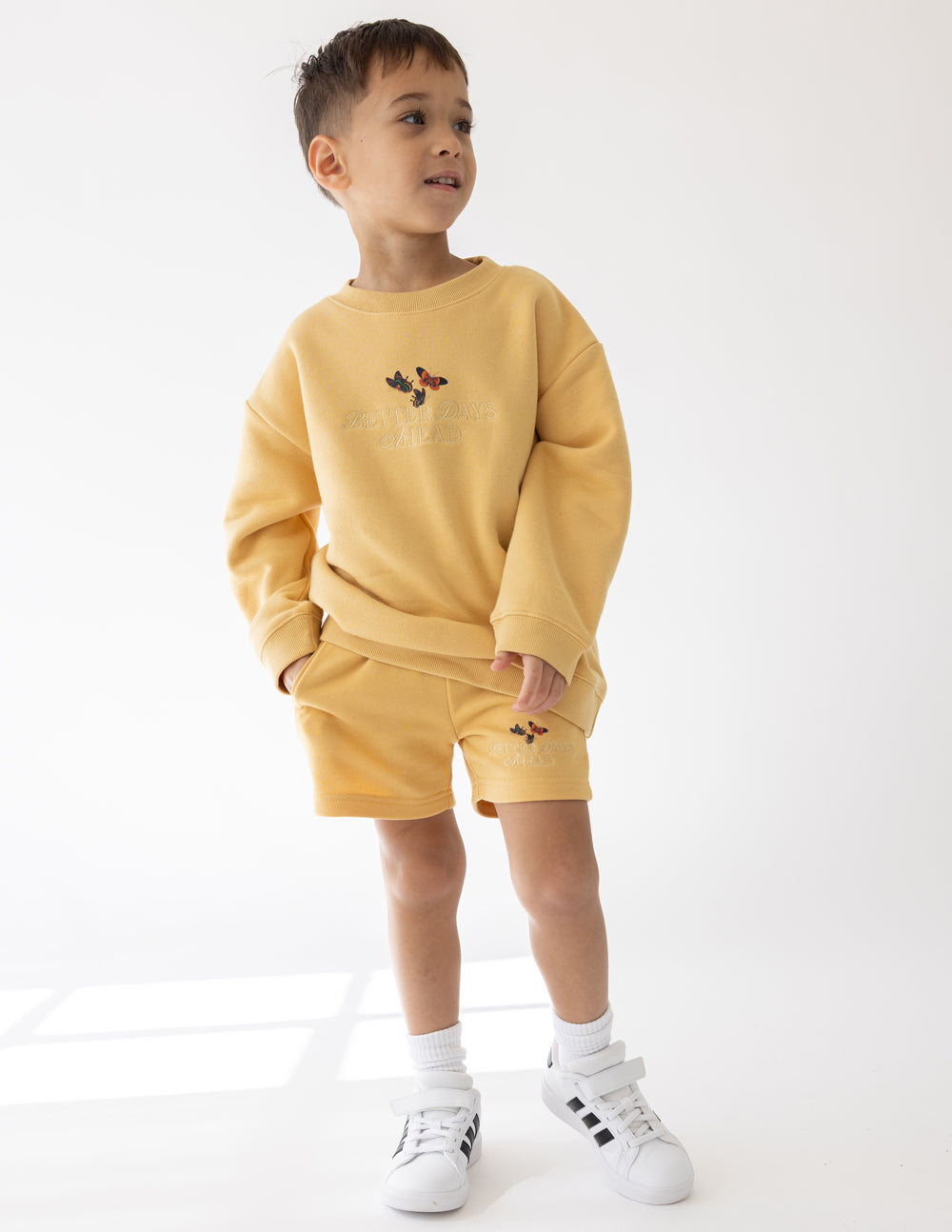 Kids yellow crewneck sweatshirt with butterfly chest graphic and long sleeves