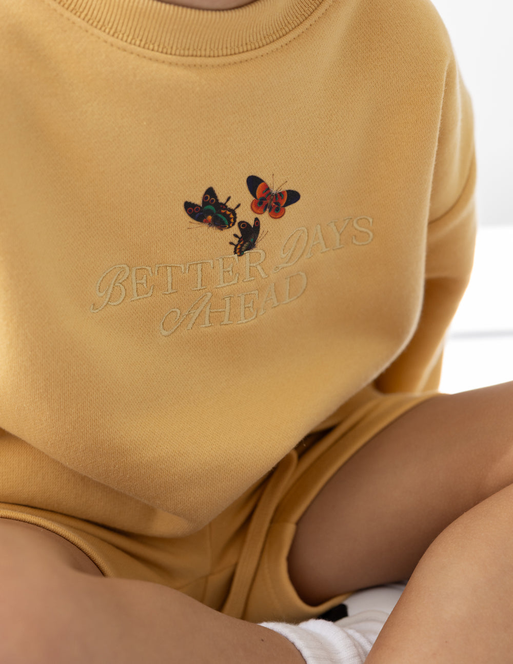Kids yellow crewneck sweatshirt with butterfly graphic and 'Better Days Ahead' text