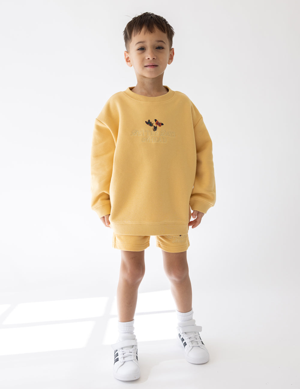 Kids yellow crewneck sweatshirt with butterfly chest graphic and ribbed cuffs