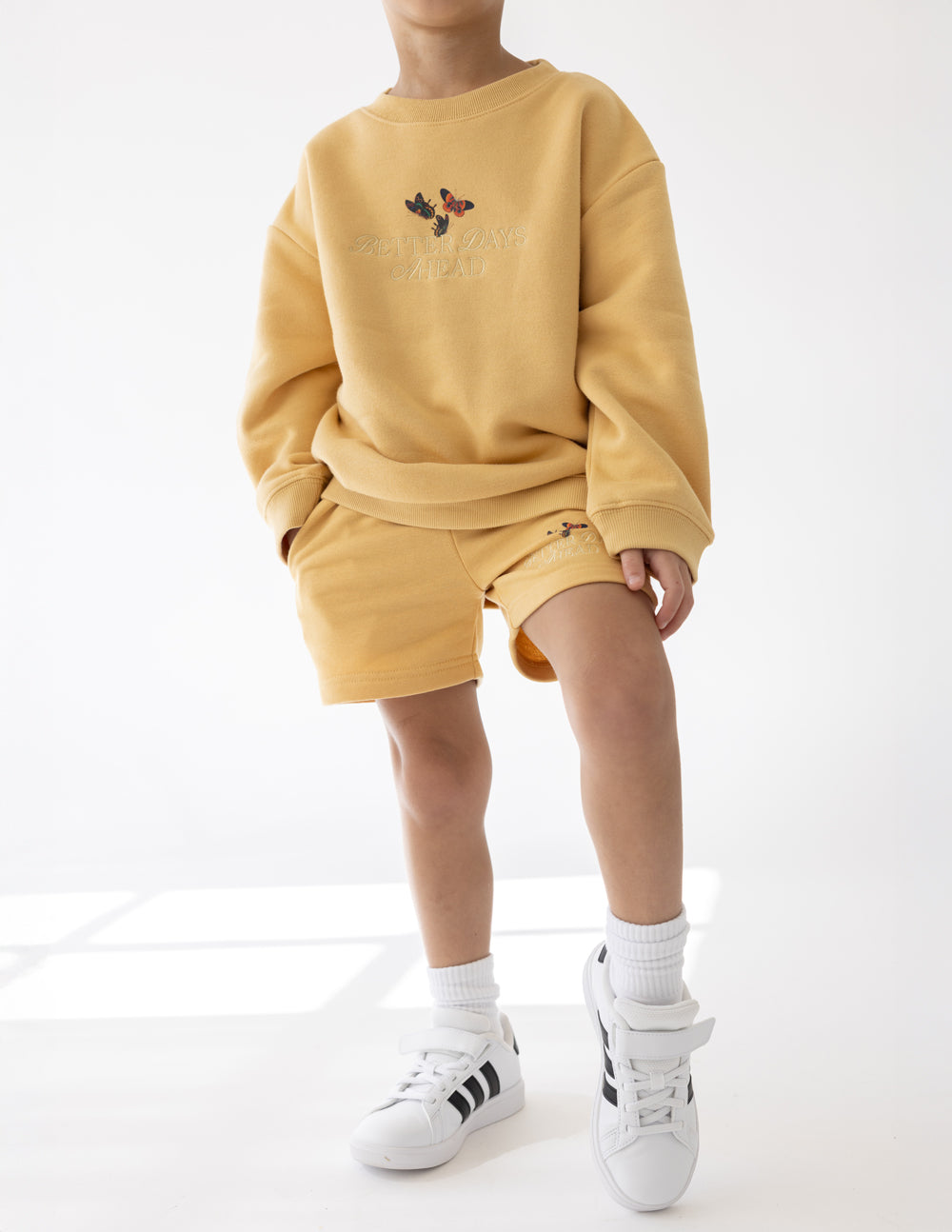 Kids yellow crewneck sweatshirt with butterfly chest graphic and relaxed long sleeves