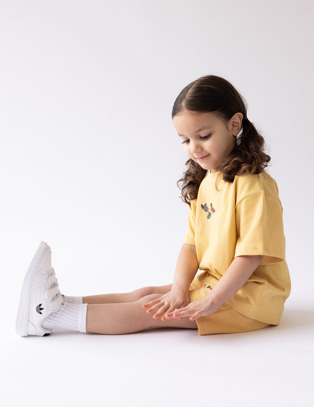 Kids butterfly graphic T-shirt in mustard yellow, worn with shorts