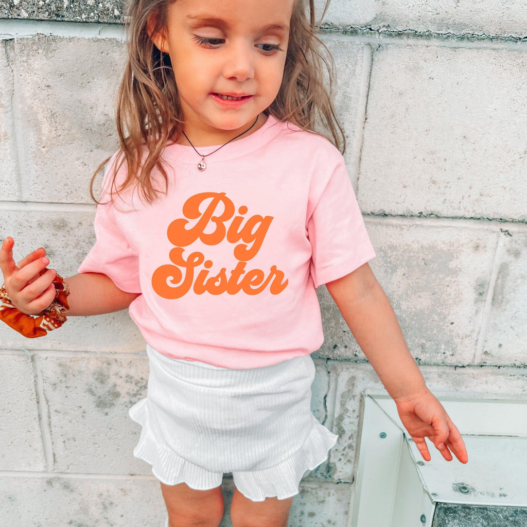 Pink baby T-shirt with orange 'Big Sister' text on the front