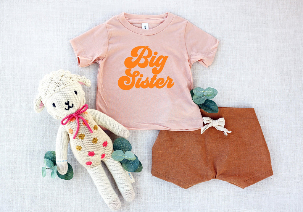 Light pink T-shirt with orange 'Big Sister' logo and matching shorts
