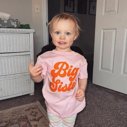 Pink baby and toddler T-shirt with orange 'Big Sister' front print