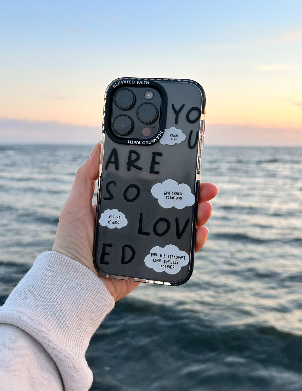 Clear phone case with black border and “YOU ARE SO LOVED” text with cloud notes