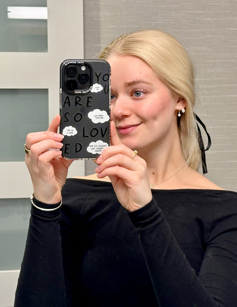 Clear phone case with black trim and stacked “YOU ARE SO LOVED” lettering