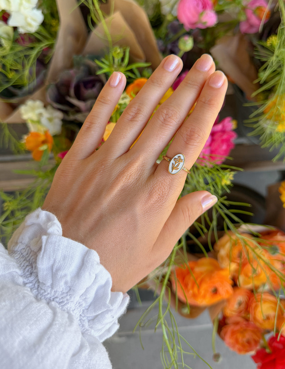 Gold oval enamel floral ring set on a slim band