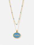 Layered gold necklace with blue bead accents and oval medallion pendant.