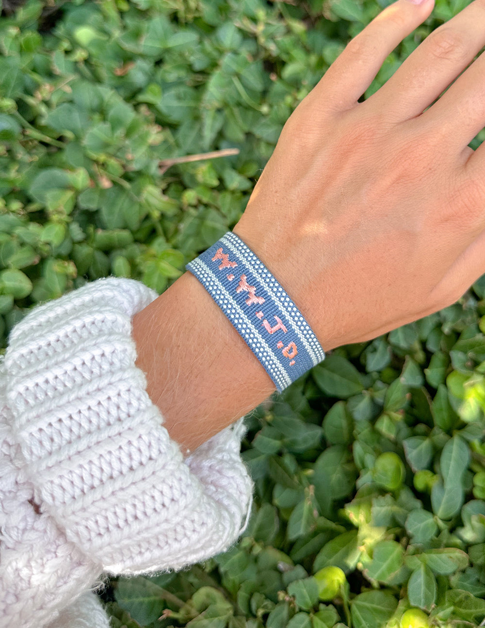 Blue fabric bracelet with embroidered letters and fringe tassels
