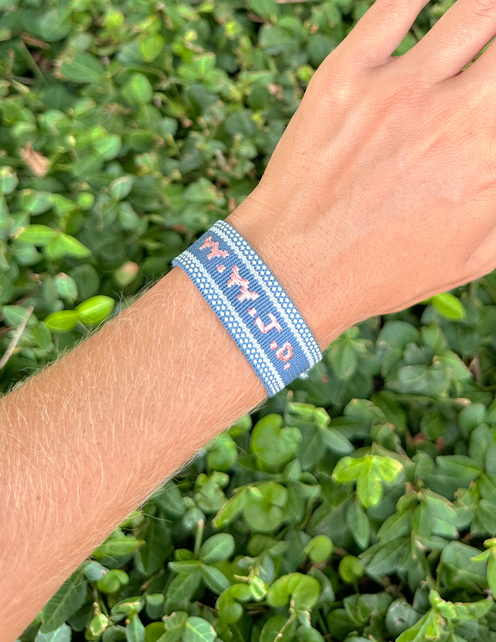 Blue embroidered bracelet with woven band on wrist