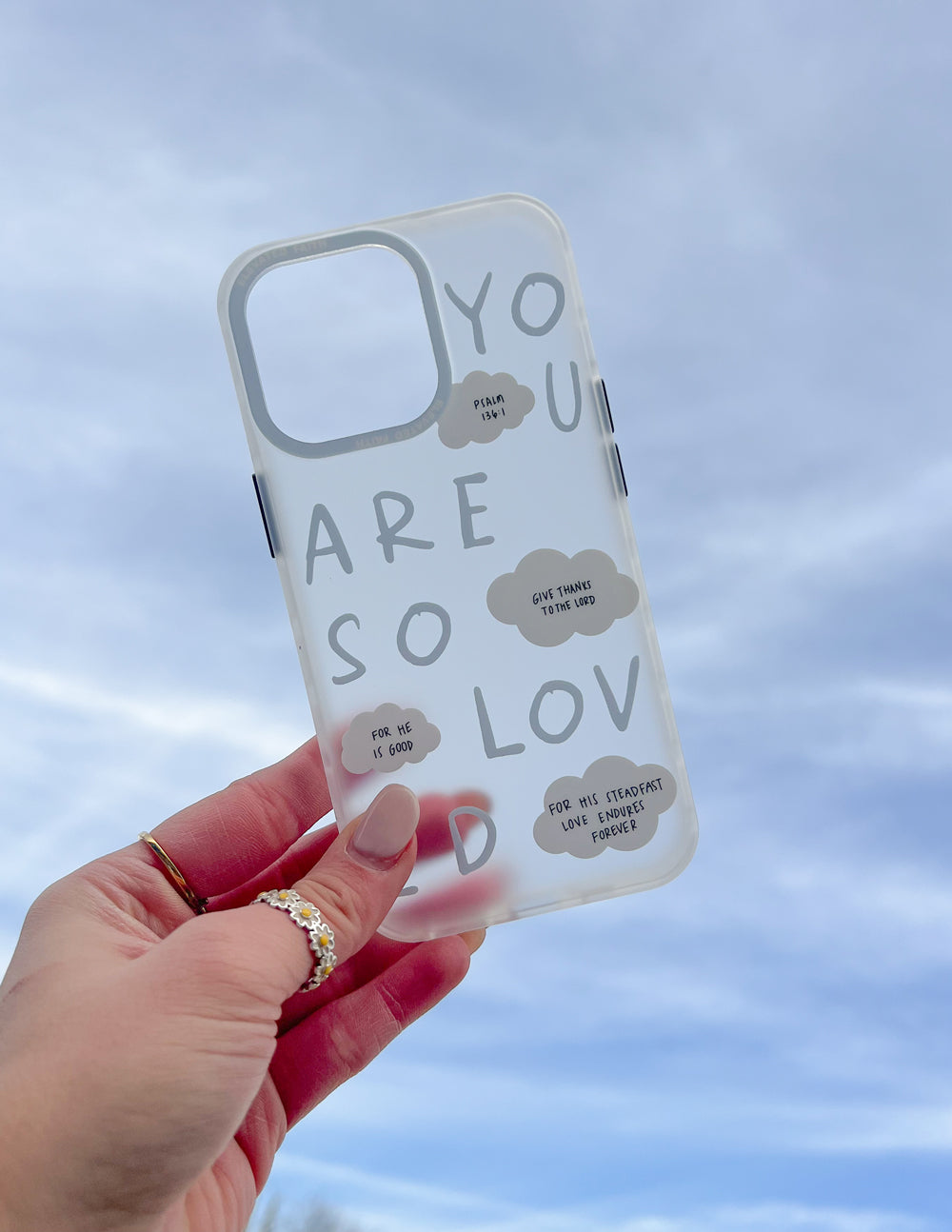 Frosted blue phone case back with white word art, cloud accents, and camera cutouts
