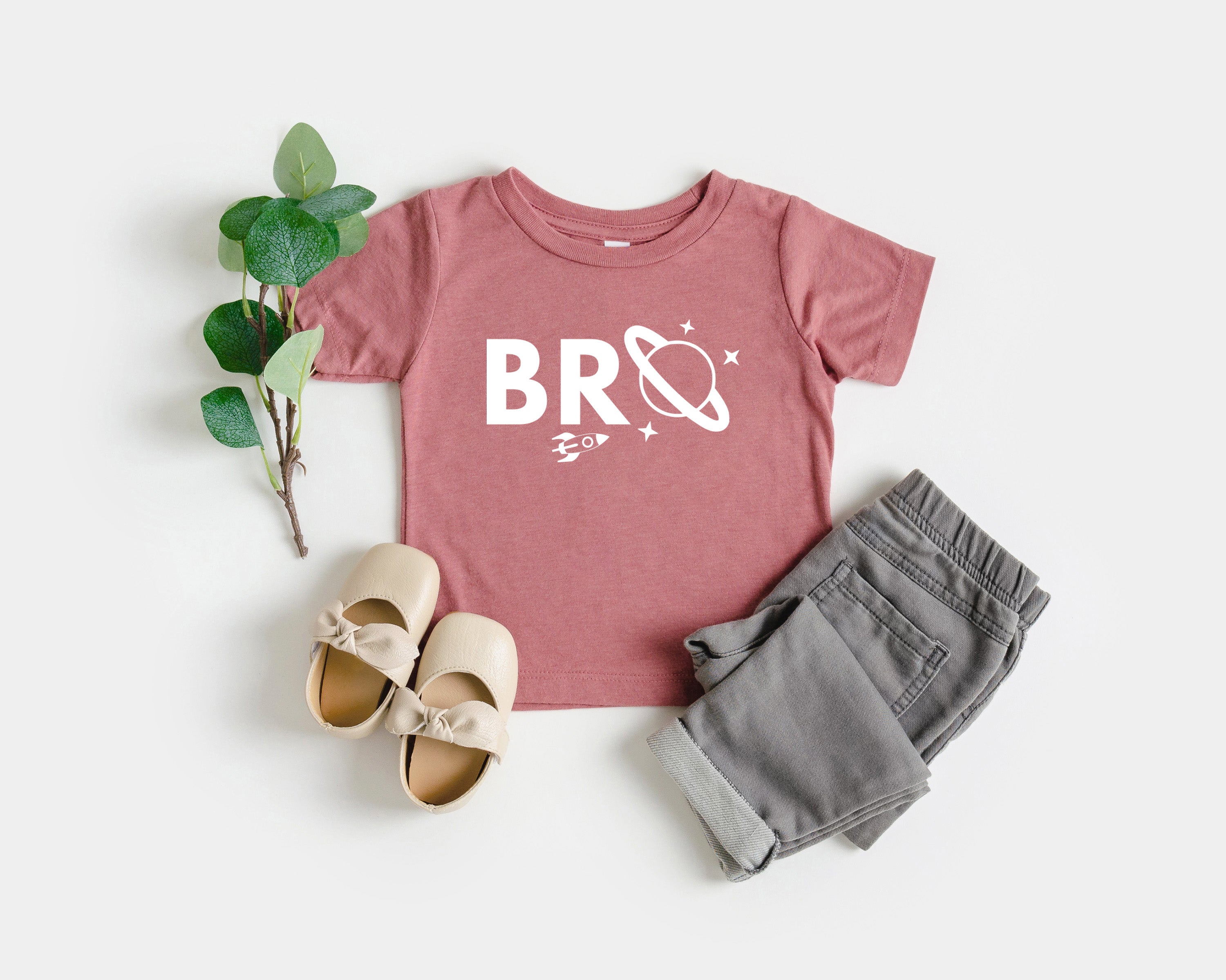 Baby and kids space-themed T-shirt, pink with white “BRO” logo graphic and small stars.