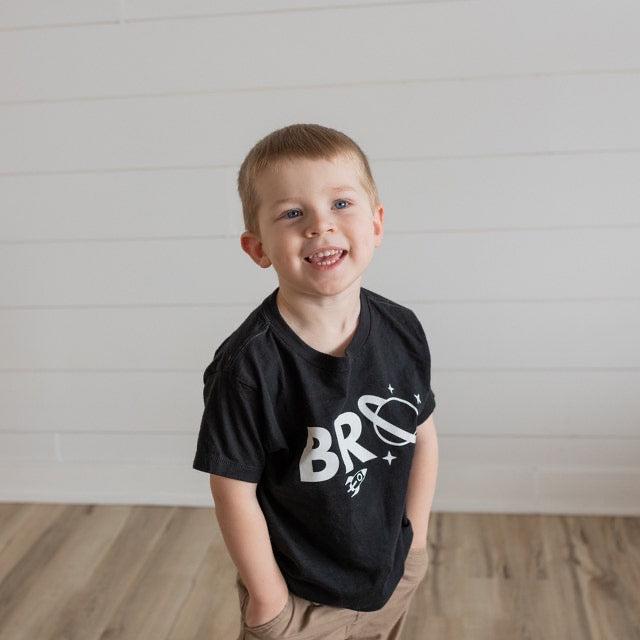 Baby and kids space-themed T-shirt, black with large white “BRO” graphic on chest.