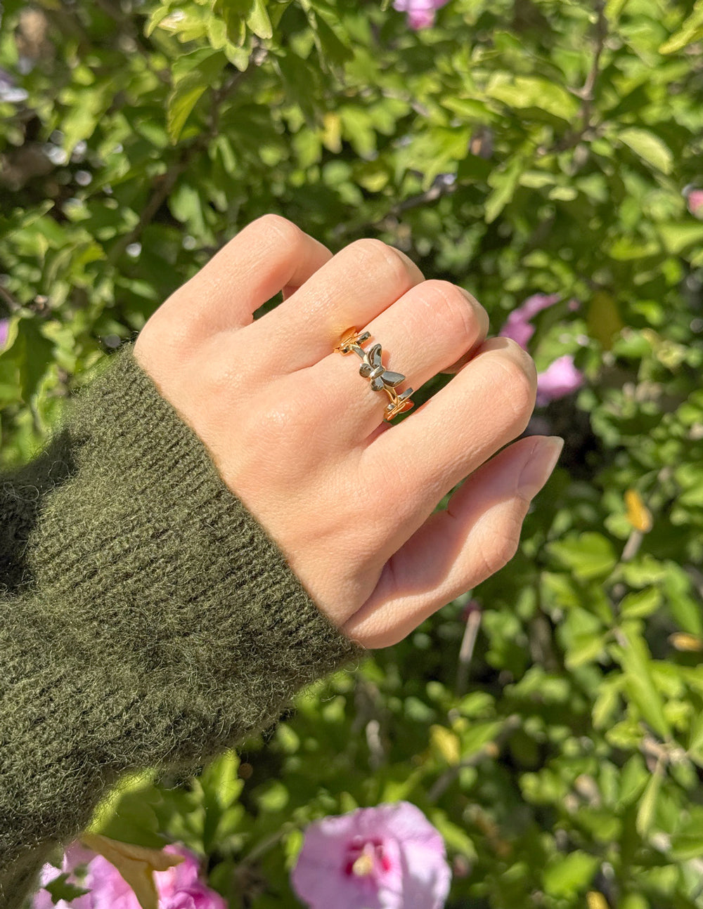 Gold butterfly motif ring with small green stone details