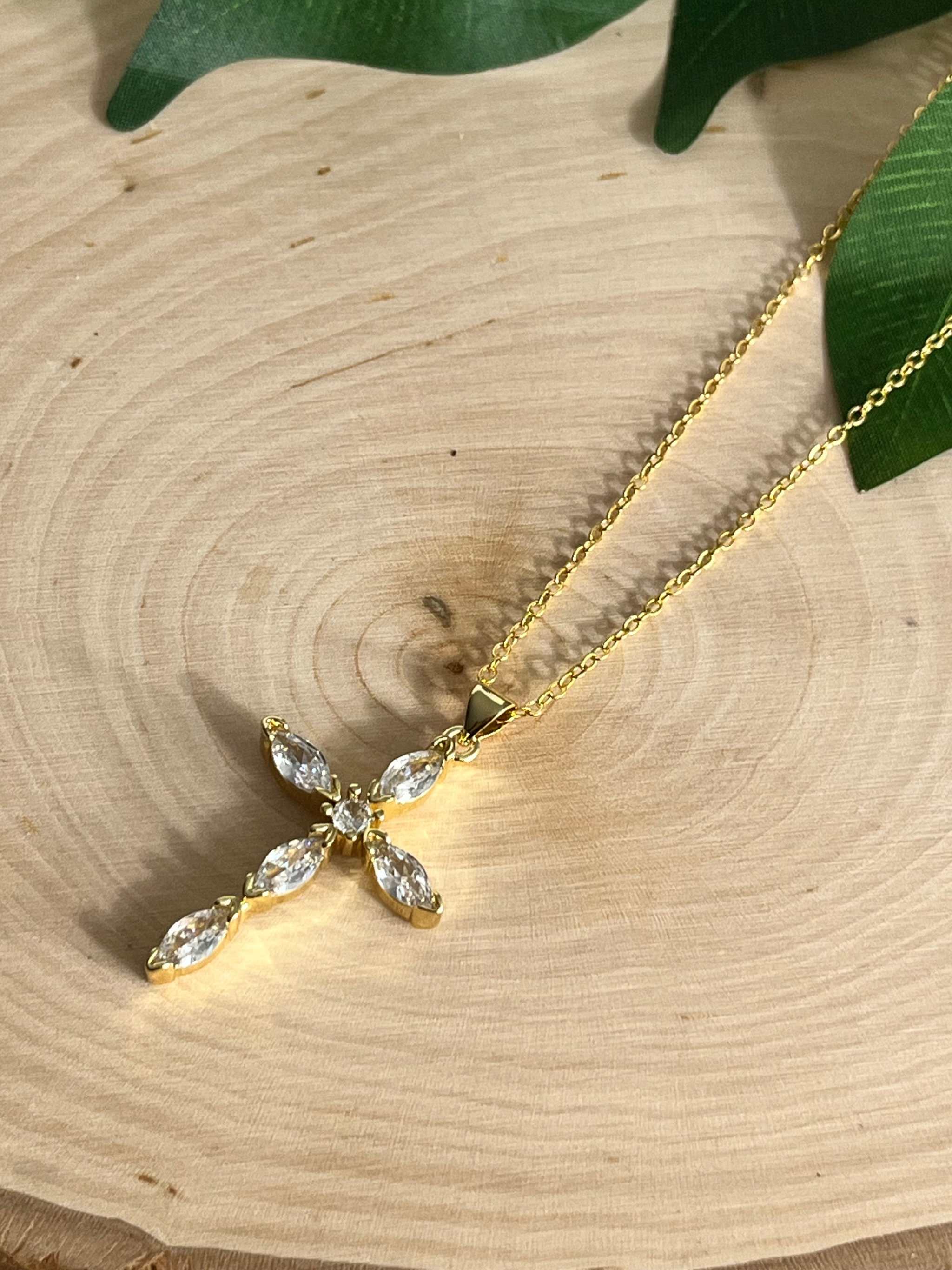 Gold cross pendant necklace with clear crystal cross centerpiece on a fine chain