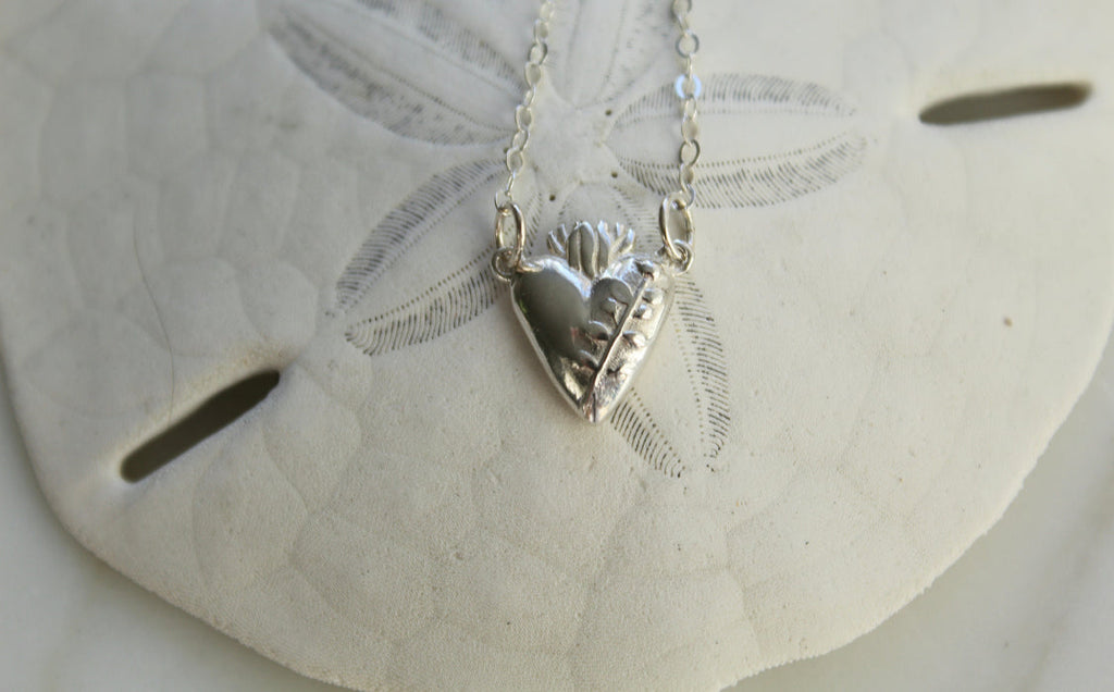 Sterling silver heart pendant necklace on a white lace disc, raised heart and chain