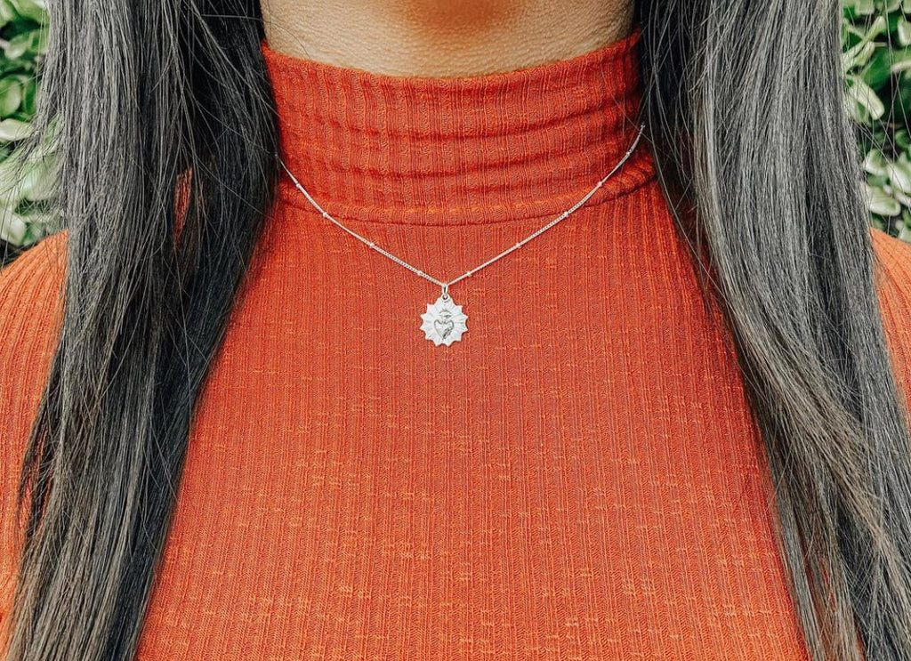 Sterling silver heart pendant necklace worn at the collar