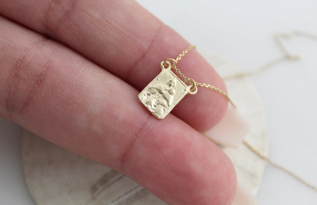 14k gold scapular charm pendant with saint relief on fine chain, close-up