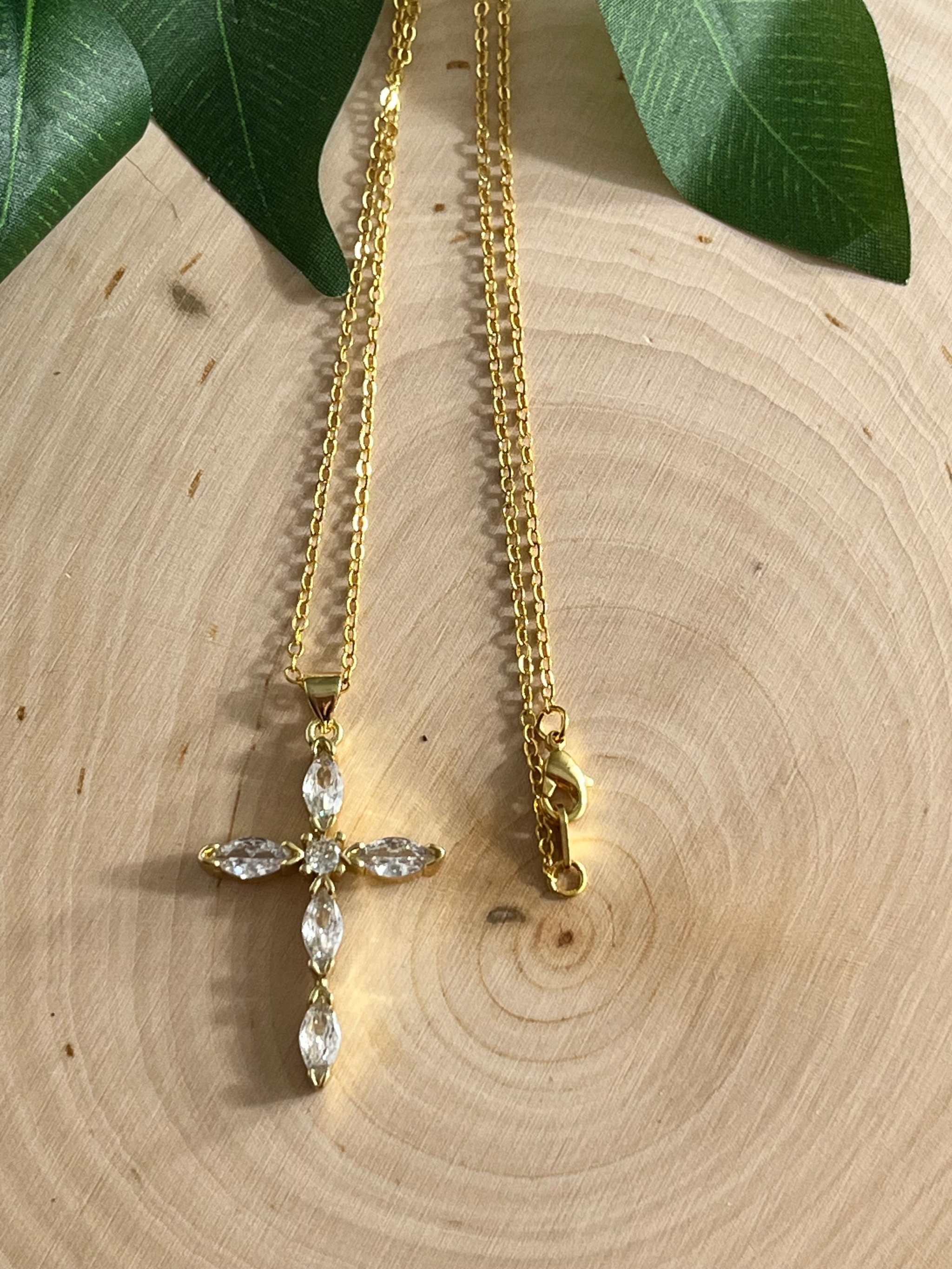 Gold cross pendant necklace with clear crystals and a lobster clasp chain end