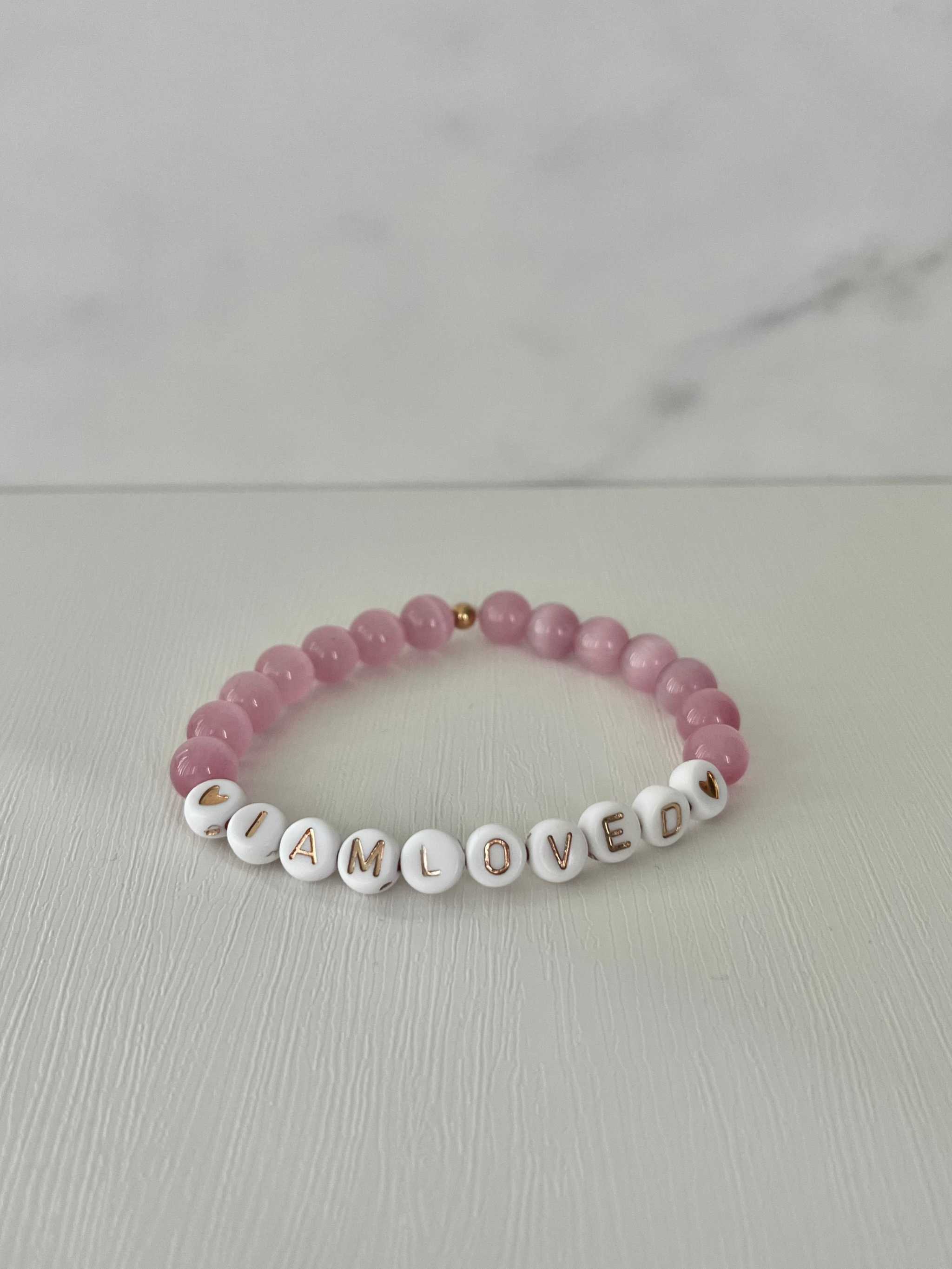 Pink beaded bracelet with 'I AM LOVED' letter beads
