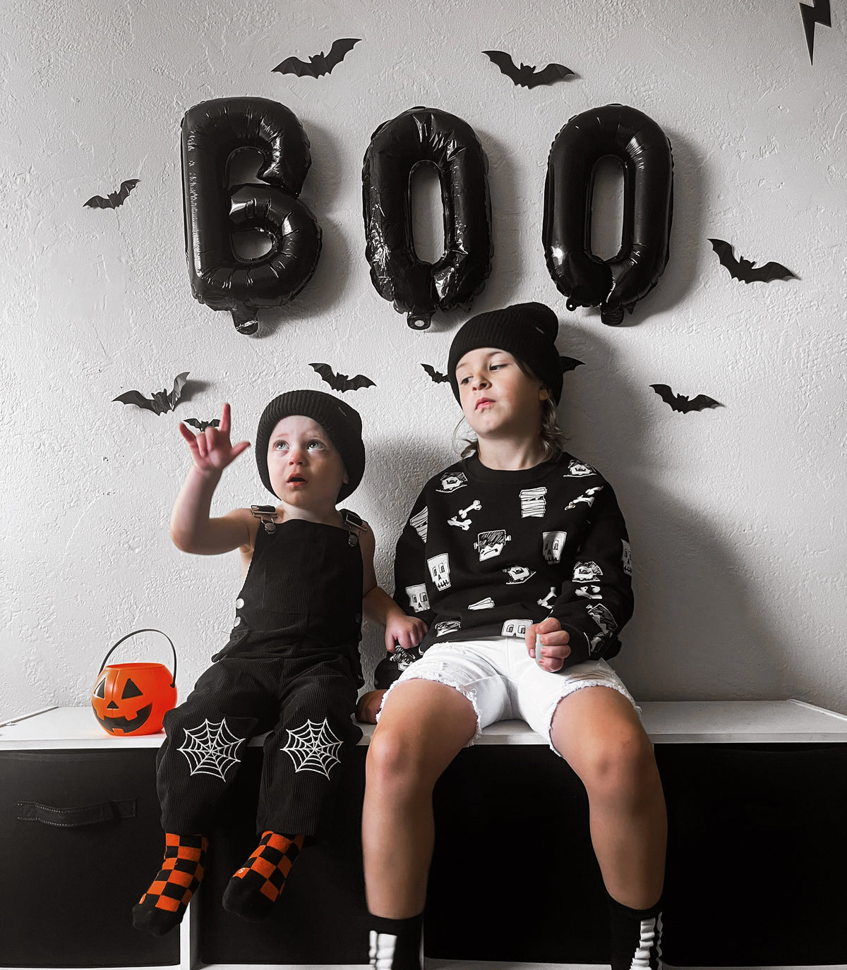 Black spiderweb overalls with front straps and web designs on knees and shins.