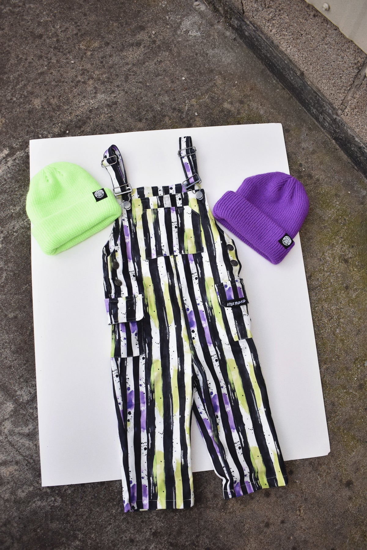Kids Halloween overalls in black, white, neon green, and purple striped fabric