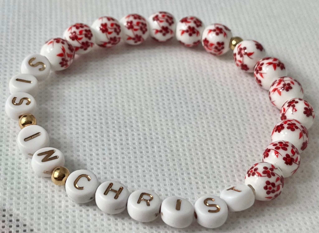 Red bead bracelet with white letter beads spelling IN CHRIST and red floral beads