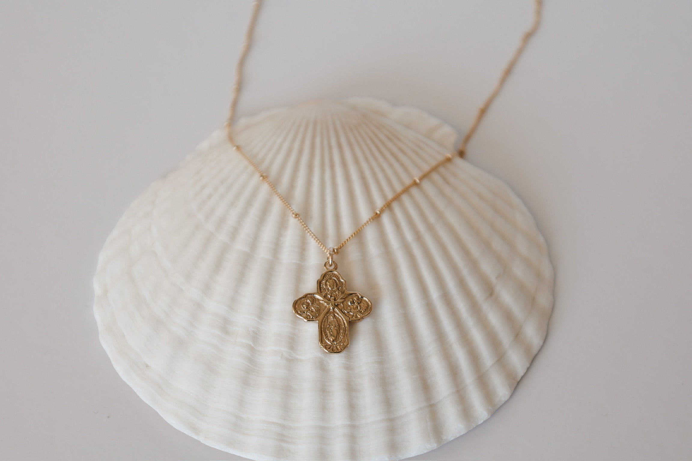 Gold cross necklace with small filigree cross pendant on a thin chain
