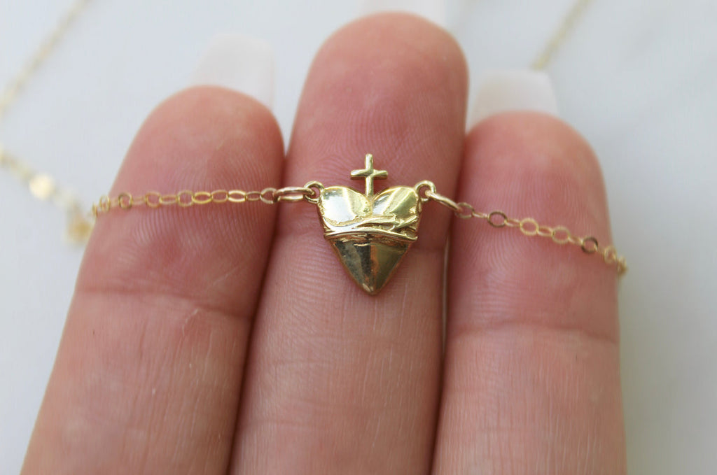Gold-tone heart charm necklace with crown top and cross detail