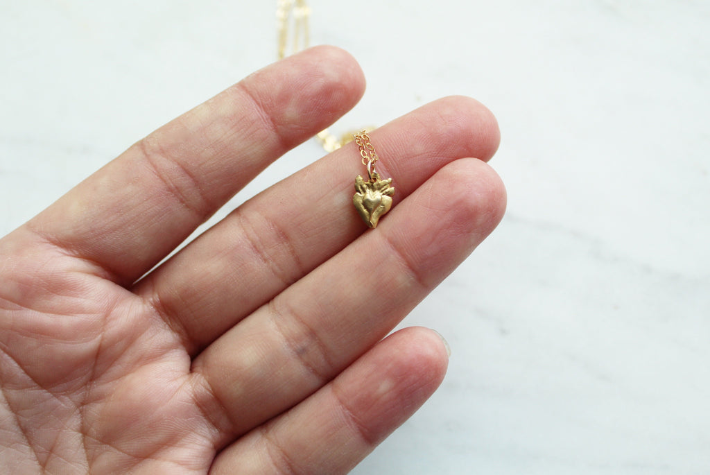 Tiny gold heart pendant on a fine necklace chain