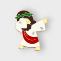 Cartoon enamel pin of Jesus dabbing, gold-tone with white, red, and green details
