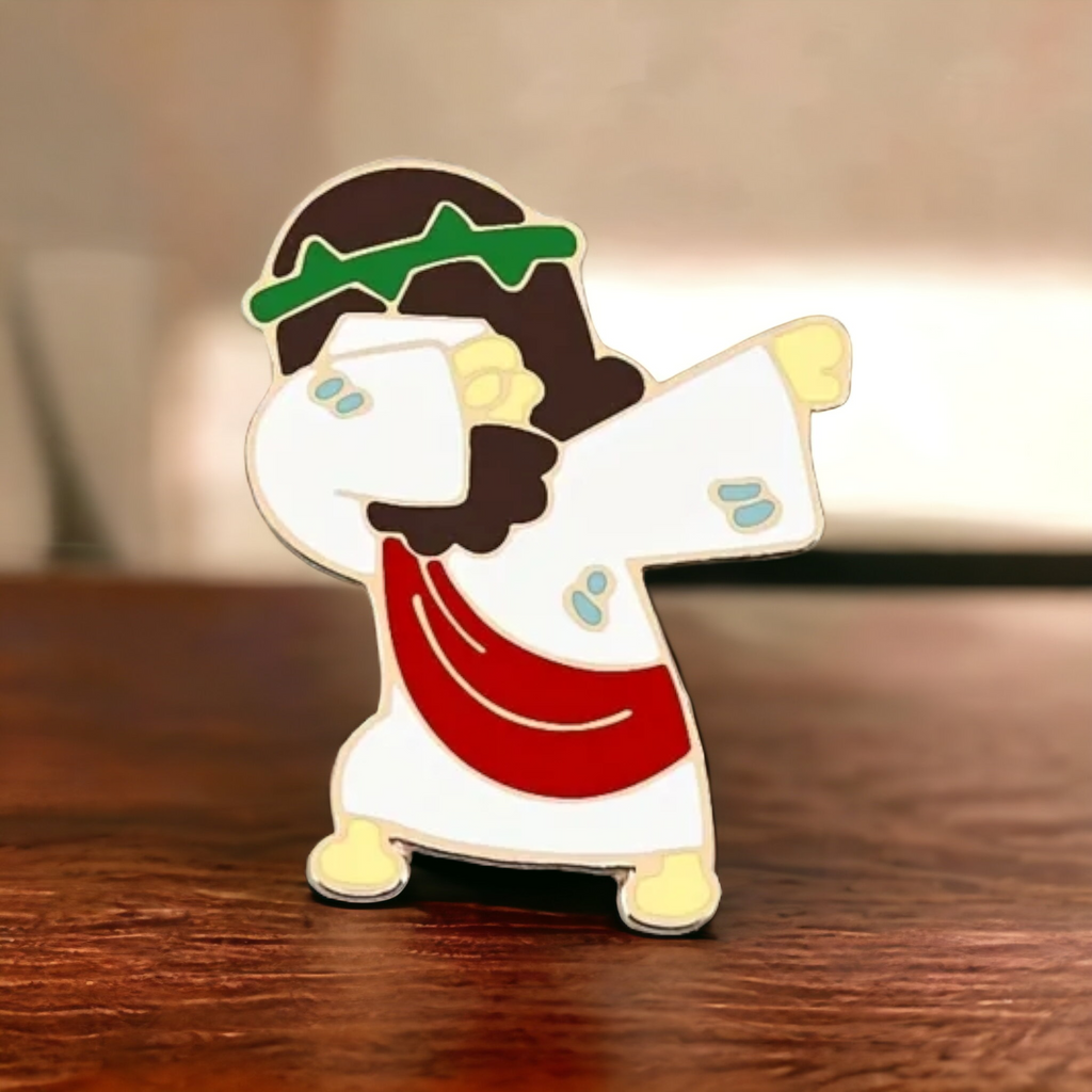 Jesus dabbing enamel pin, gold-tone character with white face, red shirt, green cap