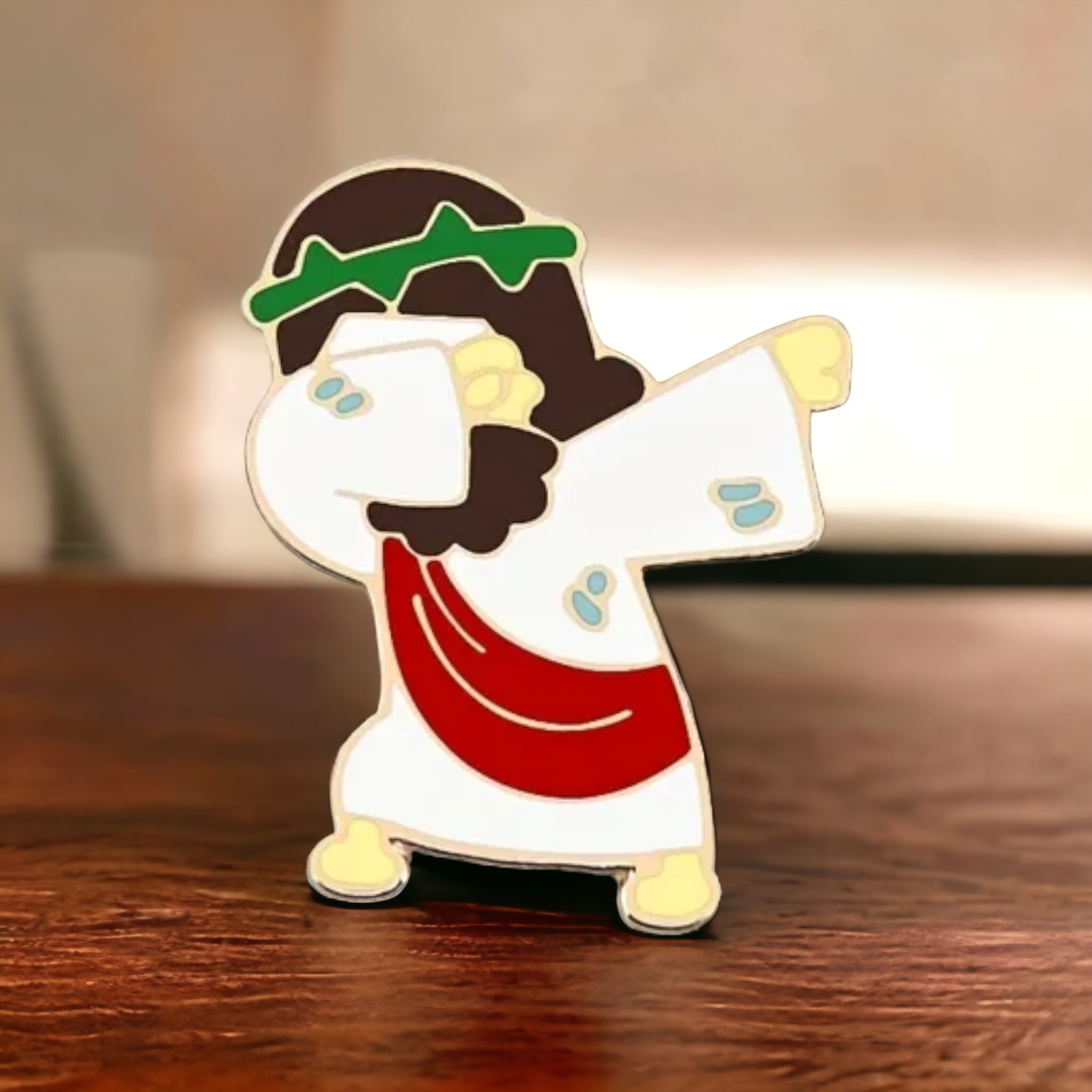 Jesus dabbing enamel pin, gold-tone character with white face, red shirt, green cap