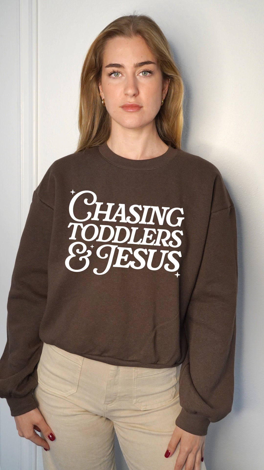 Women’s cropped sweatshirt in brown with Chasing Toddlers & Jesus front graphic