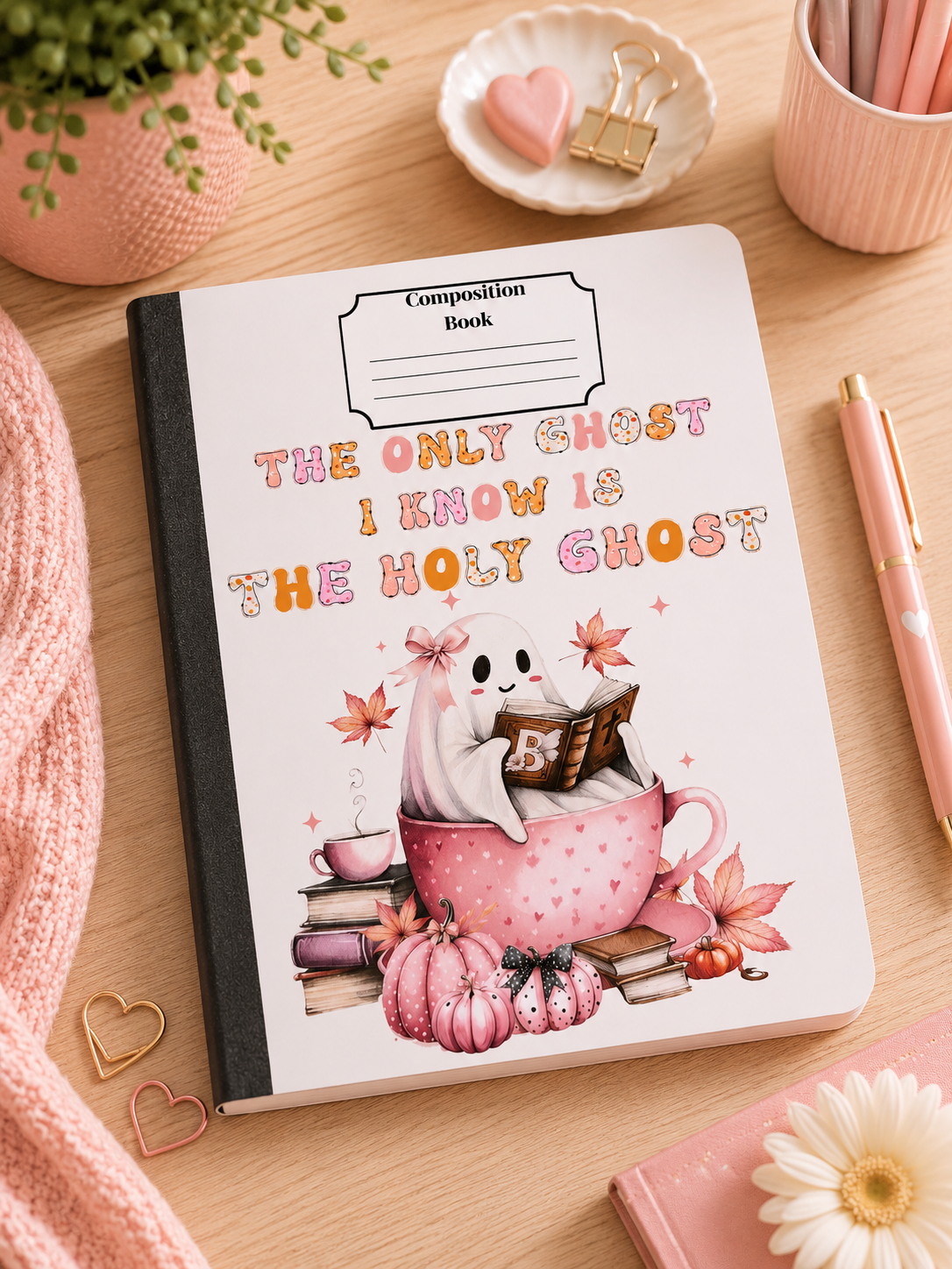Composition book with ghost holding a book, pink floral leaf design on cover