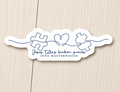 White die-cut sticker with blue puzzle-piece graphic and script text