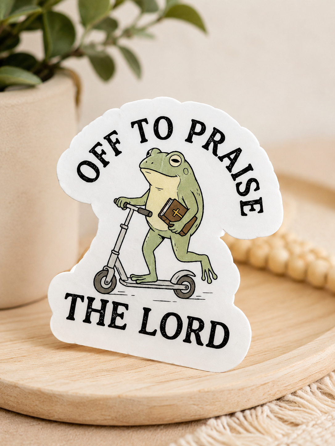 Christian frog sticker with text "Off to Praise the Lord" and frog holding a cross
