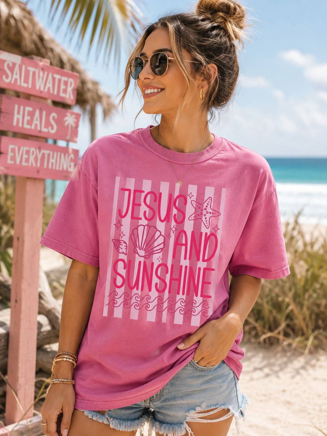 Pink graphic T-shirt with text "Jesus and Sunshine" and seashell illustration