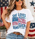 White graphic crewneck T-shirt with stars and text 'She Loves Jesus and America Too'