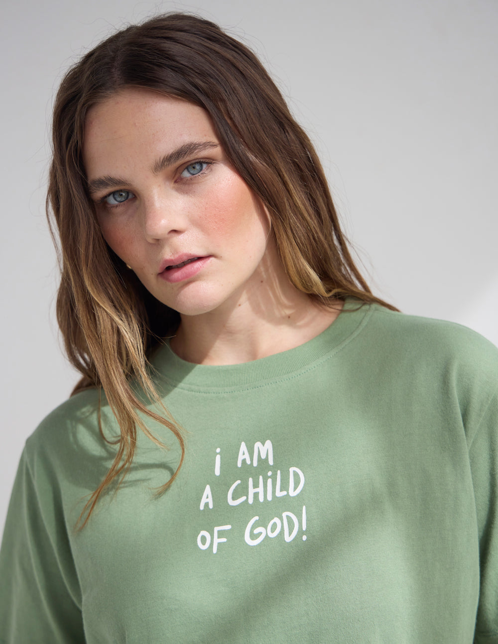 Close-up of green cropped women’s tee with “I AM A CHILD OF GOD!” front print